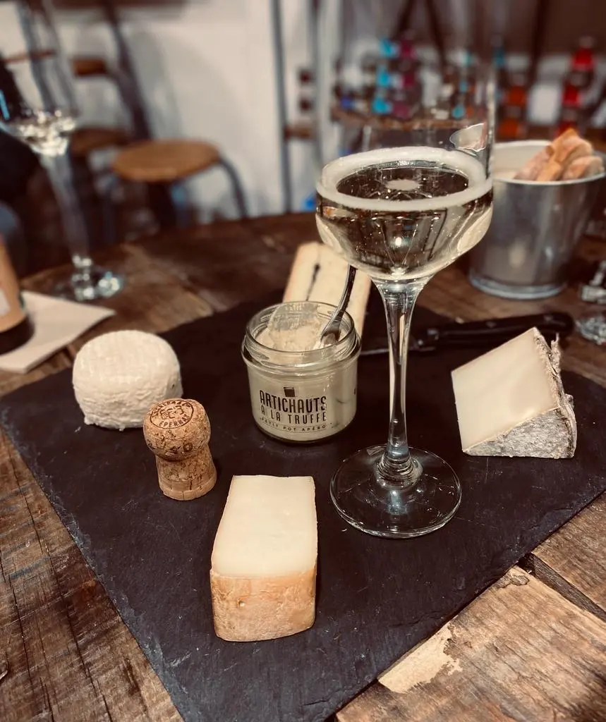 Photo d'une planche apéro avec fromage et vin blanc chez Jeanine & Gisèle